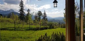 einen Blick aus einem Fenster eines Feldes mit einem Zaun in der Unterkunft Apartamenty Toporowa Cyrhla in Zakopane