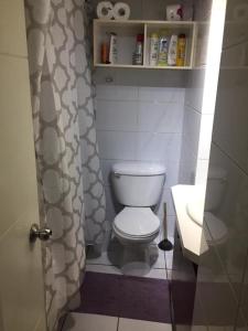 y baño con aseo blanco y lavamanos. en Apartamento Metro Santa Lucia, Santiago Centro, en Santiago