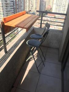 una mesa y 2 sillas sentadas en un balcón en Apartamento Metro Santa Lucia, Santiago Centro, en Santiago
