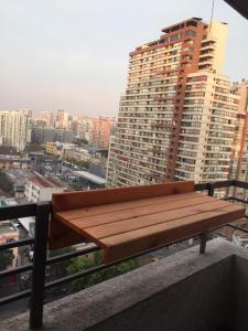 a wooden bench sitting on top of a building at Apartamento Metro Santa Lucia, Santiago Centro in Santiago
