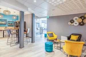 a lobby with chairs and a kitchen and a table at ibis Blois Centre Château in Blois