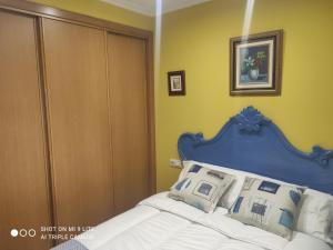 a bed with a blue headboard in a bedroom at CASA BOREAL in Ourense