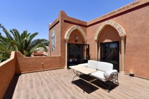 a patio with a table and chairs in front of a building at Oscar Hotel by Atlas Studios in Ouarzazate +51 photos