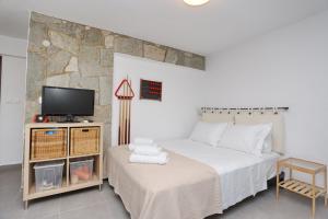 Un dormitorio con una cama, un televisor y una silla. en K-Home villa, your enchanting getaway, en Pefkohori
