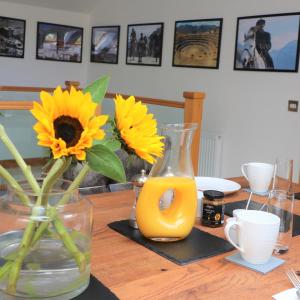 een tafel met zonnebloemen en een vaas met sinaasappelsap bij Inverness House in Inverness