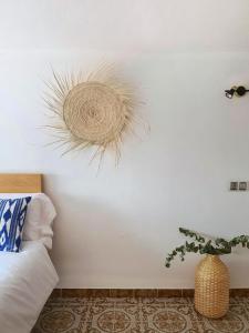 a bedroom with a white wall with a rattan decoration at Eco Finca Sa Font Blava in Llucmajor