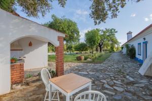 une table et des chaises installées à côté d'un bâtiment dans l'établissement Herdade do Vale da Abelheira by MyStay, à Grândola