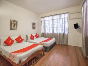 dwa łóżka w pokoju z oknem w obiekcie OYO 588 Sunrock Resort w mieście Antipolo