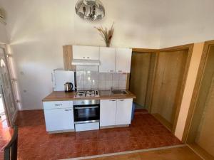 a kitchen with white cabinets and a stove top oven at Apartment Zdenka in Vir