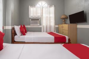 a bedroom with two beds and a television in it at OYO 588 Sunrock Resort in Antipolo