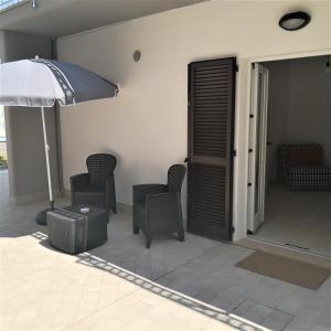 eine Terrasse mit 2 Stühlen und einem Sonnenschirm in der Unterkunft Grazioso Bilocale al mare in Marcelli
