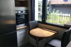 una pequeña cocina con una mesa de madera y una ventana en Hortillonne, en Amiens