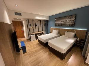 a hotel room with two beds and a television at Hotel Senac Ilha do Boi in Vitória