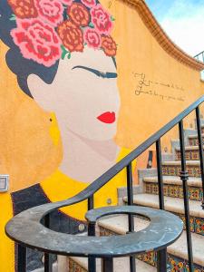 a mural of a woman with flowers on a wall at Hotel Boutique Santo Cuervo in Bernal