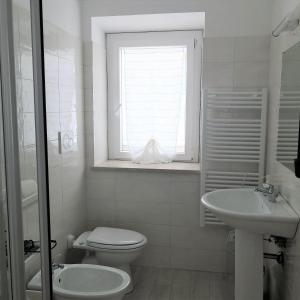 ein weißes Bad mit einem WC und einem Waschbecken in der Unterkunft Grazioso Bilocale al mare in Marcelli