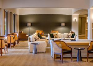 a waiting room with couches and chairs and tables at Evora Hotel in Évora