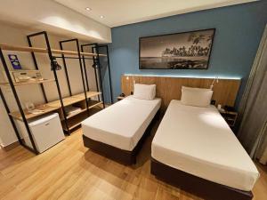 a room with two beds and a shelf at Hotel Senac Ilha do Boi in Vitória