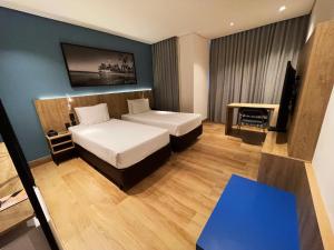 a hotel room with two beds and a desk at Hotel Senac Ilha do Boi in Vitória