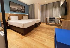 a hotel room with two beds and a tv at Hotel Senac Ilha do Boi in Vitória
