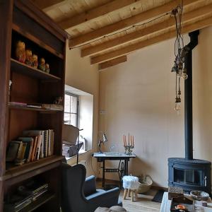 a living room with a stove and a table at L' Abilleiru Albergue Rural in Santibáñez de Valdeiglesias