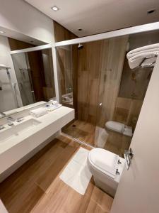 a bathroom with a sink and a toilet and a mirror at Hotel Senac Ilha do Boi in Vitória