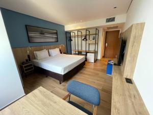 a bedroom with a bed and a chair and a television at Hotel Senac Ilha do Boi in Vitória