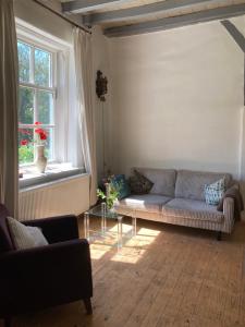 a living room with a couch and a window at B&B van Beijden in Overasselt