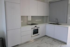 uma cozinha branca com armários brancos e um lavatório em 42 Beach Coast Apartment em Polis Chrysochous