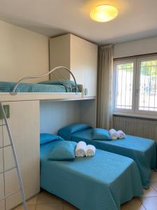 Habitación con 3 literas y sábanas azules. en Villa Desy, en Riva del Garda