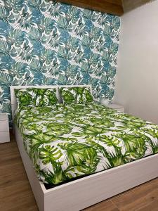 a bedroom with a bed with a green and white bedspread at Tropical House in Mola di Bari