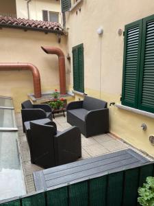 d'une terrasse avec des chaises, une table et des volets verts. dans l'établissement Civico 2 Operetta Marina, à Crémone