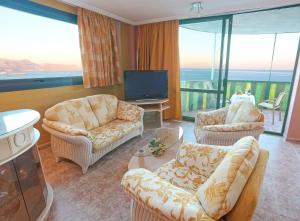 ein Wohnzimmer mit 2 Stühlen und einem TV in der Unterkunft KAKTUS Hotel Kaktus Albir in Albir