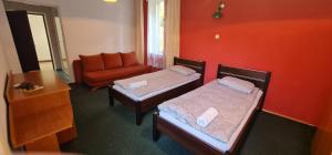 a hotel room with two beds and a couch at Kasztelanka in Krynica Zdrój