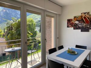 una sala da pranzo con tavolo e balcone di Villa Desy a Riva del Garda
