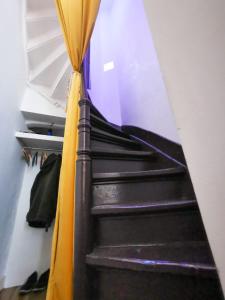 un conjunto de escaleras en una habitación con cortina amarilla en La maison des vacances, en Bruselas