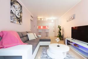 a living room with a couch and a flat screen tv at Magnifique 2 pièces Palm Beach bord mer in Cannes