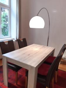 uma mesa de madeira com cadeiras pretas e um candeeiro em Apartment-Zimmer KRISTALL - großer Balkon und Parkplatz direkt im Zentrum em Bad Ischl