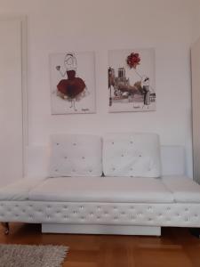 a white bench in a room with two pictures on the wall at Apartment-Zimmer KRISTALL - großer Balkon und Parkplatz direkt im Zentrum in Bad Ischl