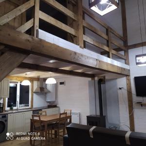 a room with a loft with a table and a kitchen at Casuta de Vacanta Marisel, Cluj in Mărişel