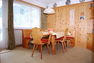 ein Esszimmer mit einem Holztisch und Stühlen in der Unterkunft Feriendomizil zum Schalten und Walten in Scuol