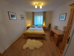 a bedroom with a bed and a desk and a window at Chata Olimpijki in Karpacz