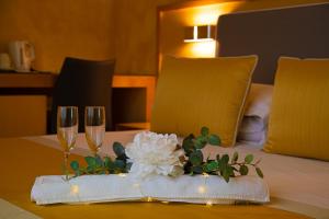 a table with two wine glasses and a white flower on it at B&B Lapillus in Pompei