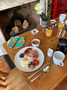 un tavolo con un piatto di prodotti per la colazione di Burleigh House B and B a Tenbury