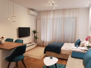 a bedroom with a bed and a table and chairs at Azura Residence - new luxury apartment in Belgrade
