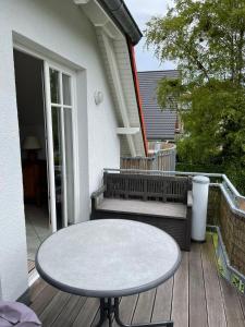 une table sur une terrasse en bois avec un banc dans l'établissement Alte Reihe 9 Wohnung 5, à Zingst