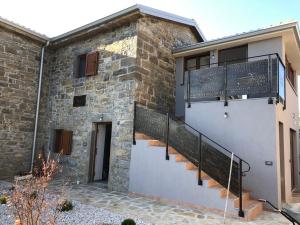 Una casa de piedra con escaleras en el costado. en Villa Sanela, en Pobegi