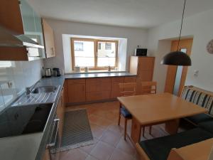 kuchnia ze zlewem i stołem w obiekcie Living Apart Haslwanter Ferienwohnung w mieście Haiming