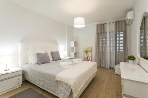 a white bedroom with a large bed and a sink at Miral 2 - Beach front apartment with pool in Quarteira +16 photos