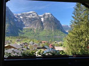 una ventana con vistas a un pueblo y a las montañas en Apartment Stadler, en Obertraun