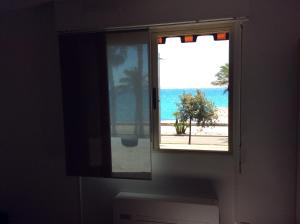 a window with a view of the beach at Poseidon in Cagnes-sur-Mer